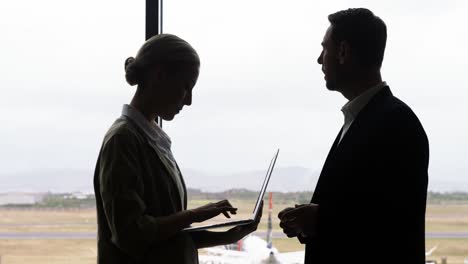 Businessman-and-woman-discussing-on-laptop