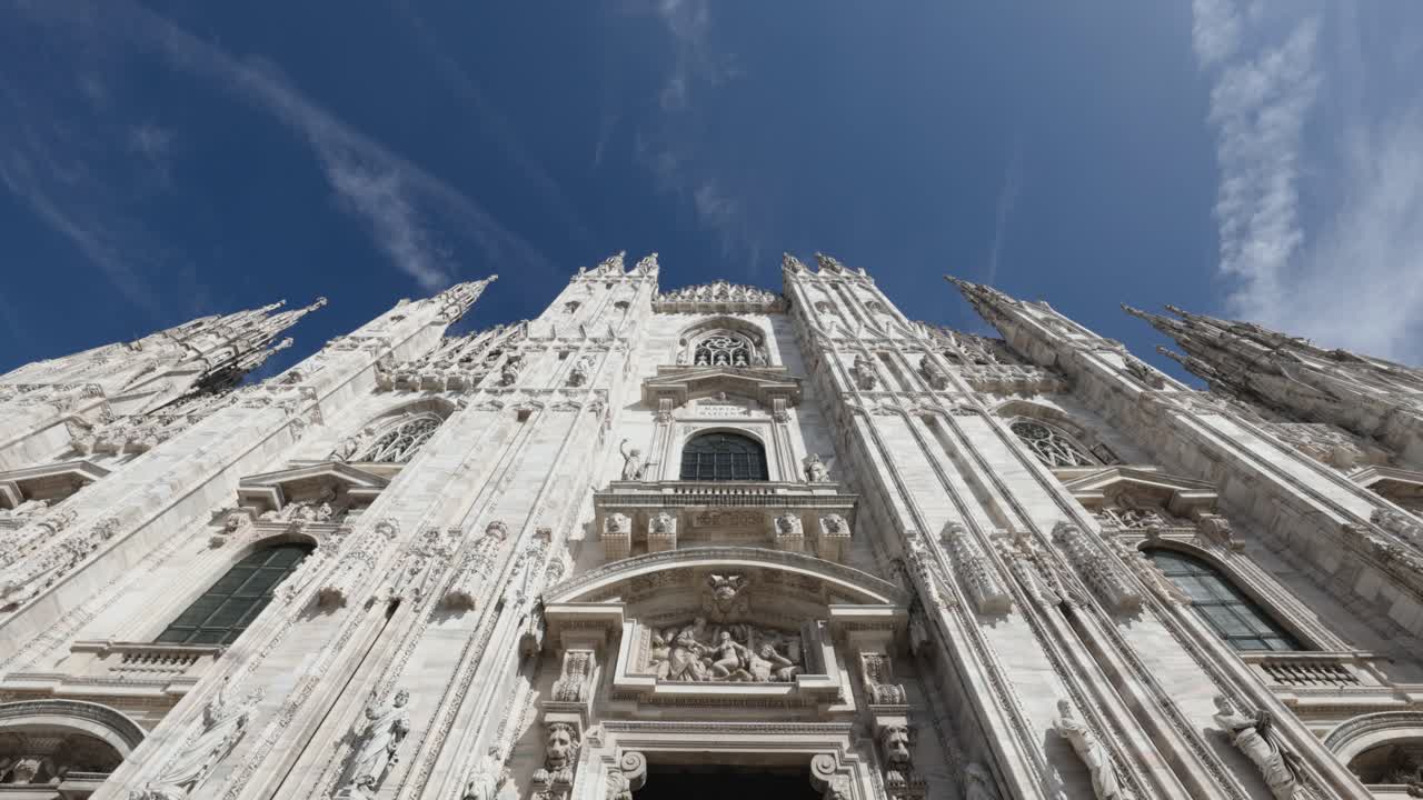 Moving towards front side of Milan Cathedral, camera tilts up