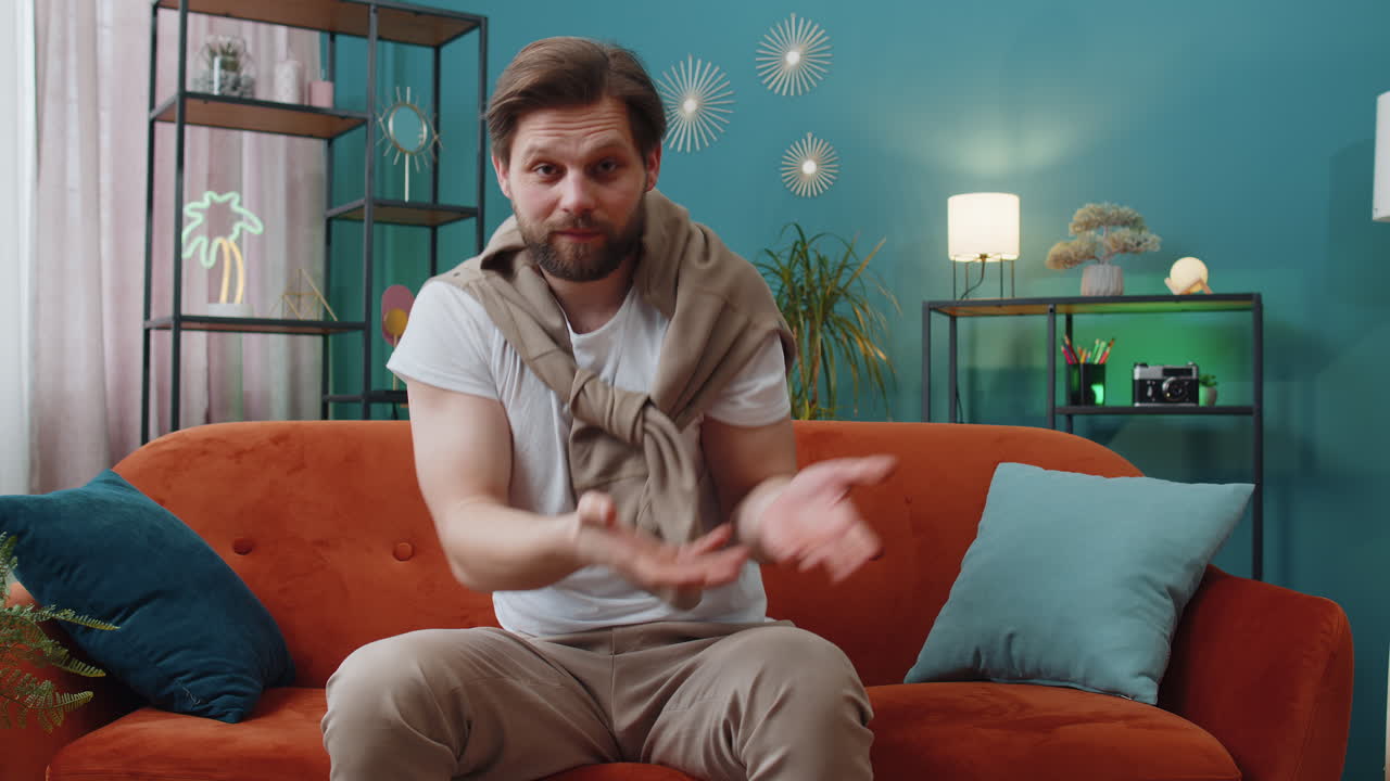 Young man raising hands asking what why reason of failure disbelief irritation by troubles at home