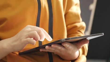 close up on the hand of caucasian woman pointing and touching the screen of tablet. technology social network and communication concept