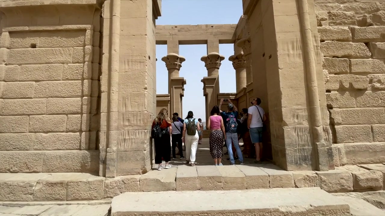 Rovine di un antico tempio egizio in Egitto. Turisti fuori dal tempio di Iside a File, Egitto. Visitatori all'interno delle mura del tempio religioso egizio a File, Assuan. Archeologia greco-romana.