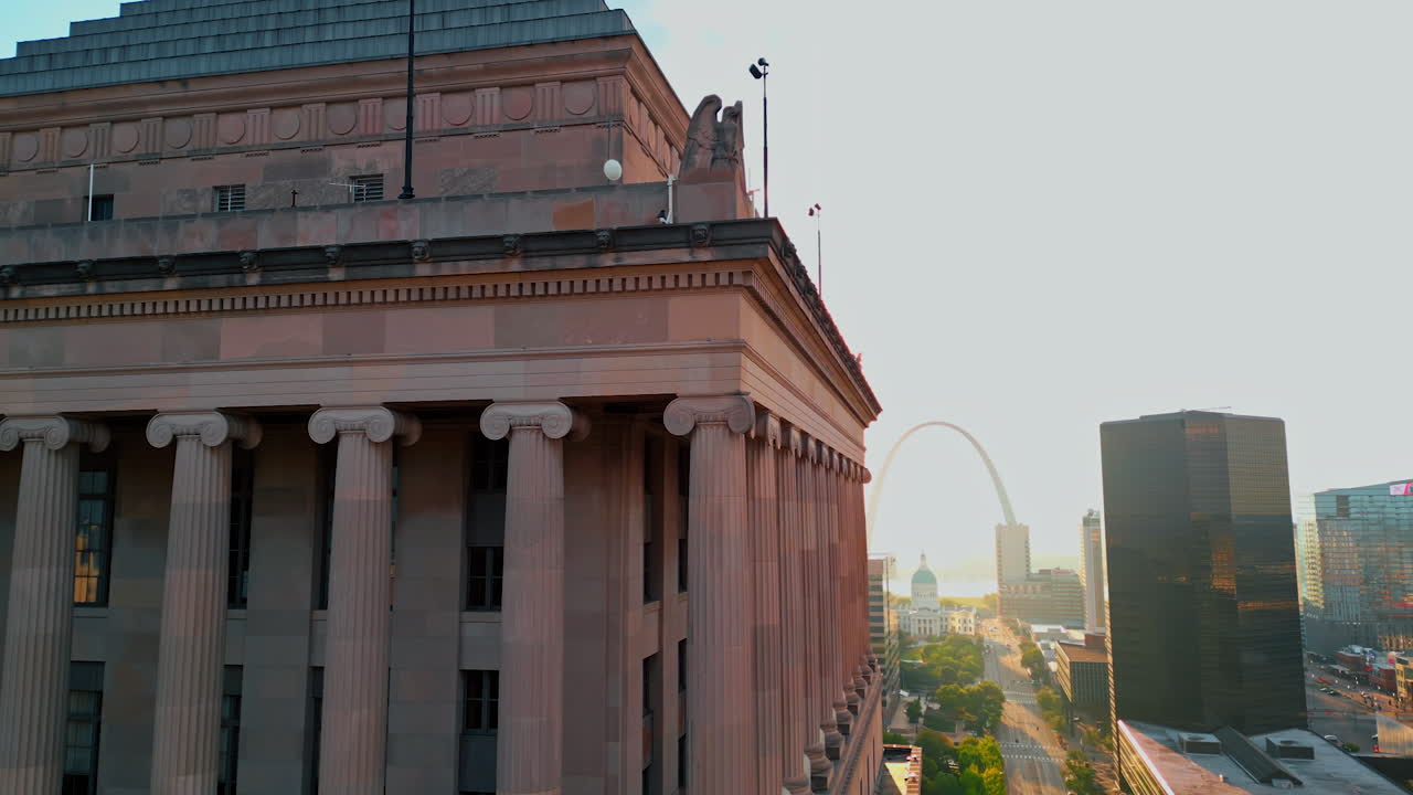 Saint Louis USA, 14 August 2025: Sphinx-like creature adorning the corners of the roof at Civil Courts Building. Bright sun dazzles the scenery and Gateway Arch at backdrop. St. Louis, Missouri, USA