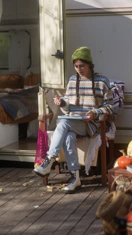 young woman drawing on a tablet in a camper