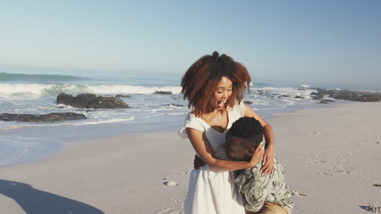 African American man cuddling and holding his wife seaside