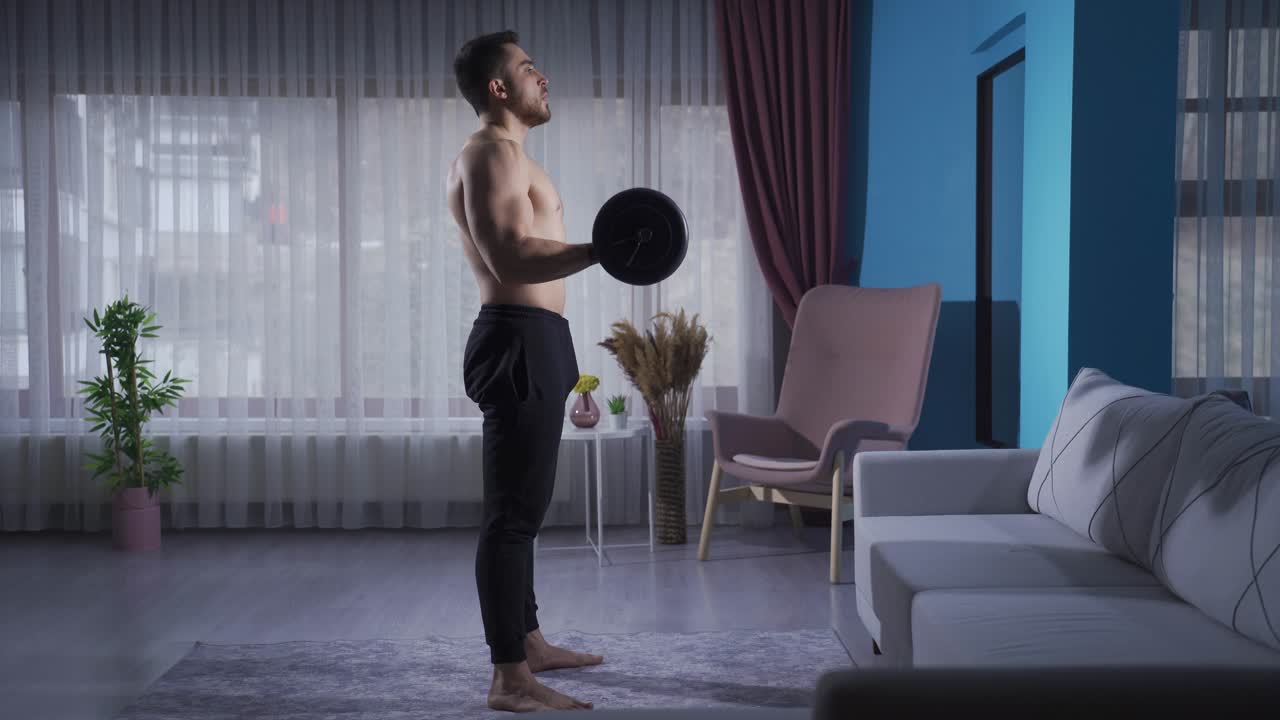 젊은 운동선수가 근육을 키우기 위해 더 열심히 일하고 있습니다. 집에서 운동하고 있습니다.