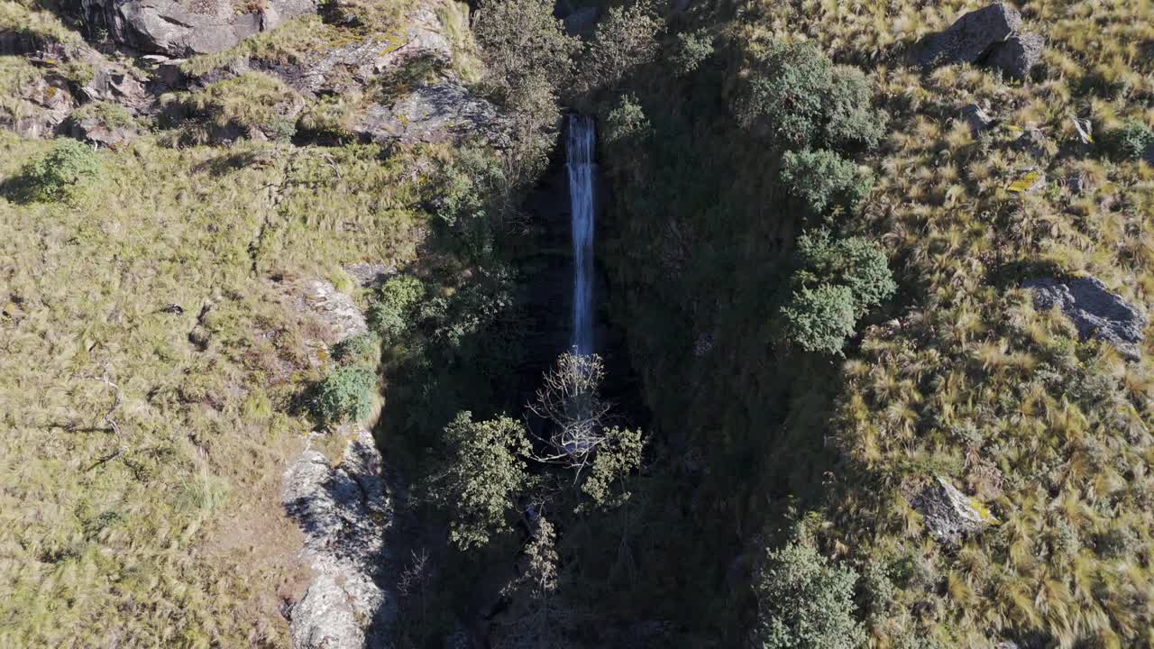 Aerial View of a Serene Waterfall Cascading Down a Lush Cliffside