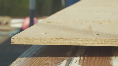 close-up of a plywood plank being cut outdoors