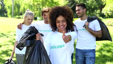 happy volunteers picking up trash in the park