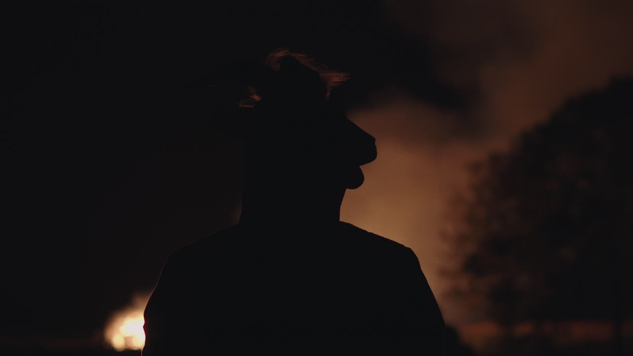 Person Silhouette at Night with Fire