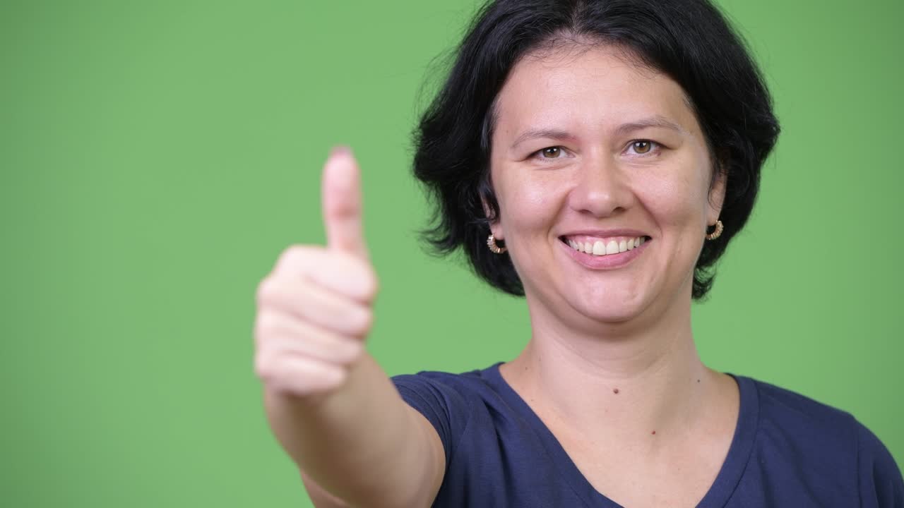 mujer hermosa con el cabello corto dando pulgares hacia arriba