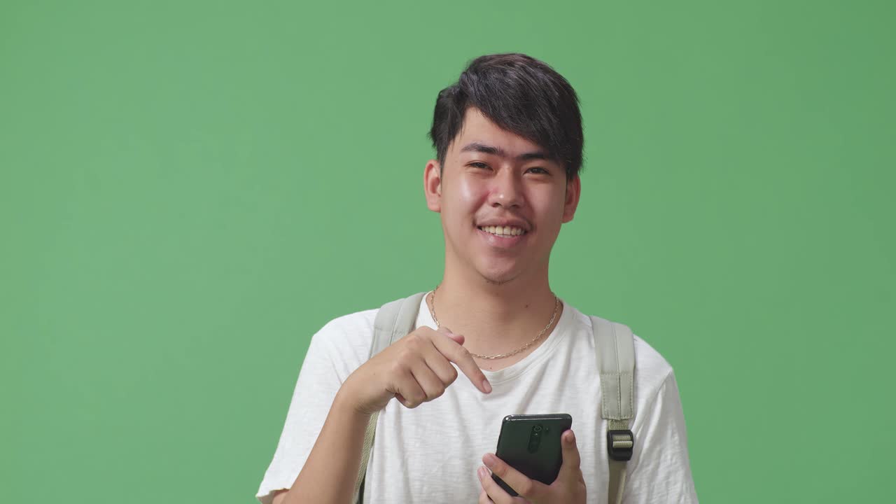 스마트폰을 들고 있는 미소 짓는 젊은 남자