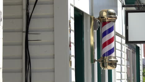 barber pole revolves on clapboard building with coax cables