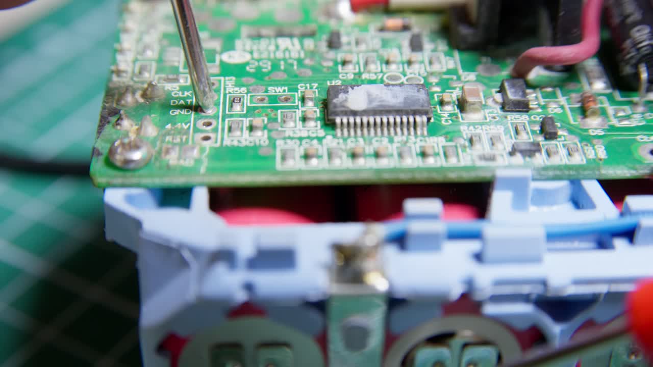Close up fault finding an electrical battery unit with a multimeter. Clip 3