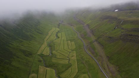 Luftaufnahme-Von-Isländischen-Bauernfeldern-Mit-Fliegendem-Nebel-Am-Himmel-In-Der-Landschaft-Von-Oben-Nach-Unten