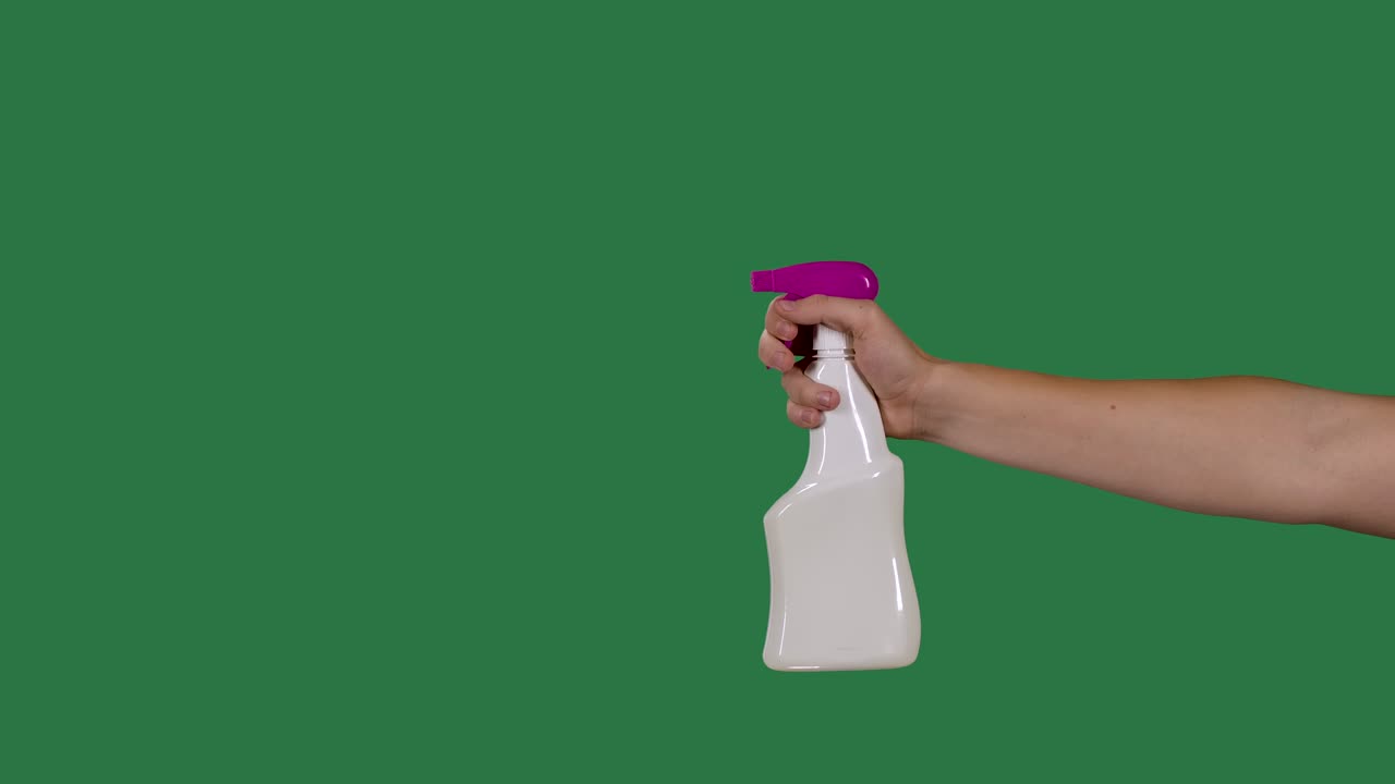 남자 손은 스프레이 병을 들고 코로나 바이러스를 살균하기 위해 살균 알코올을 스프레이합니다. 녹색 화면, 크로마 키, 느린 모션, 클로즈업.