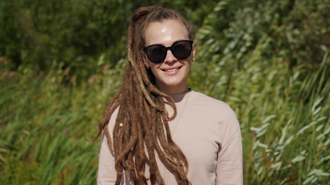 Woman with dreadlocks smiling outdoors