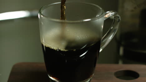 coffee being poured in a clear mug