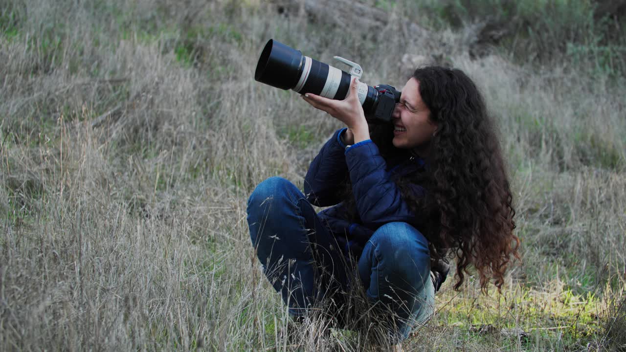 mujer fotógrafa de vida silvestre con lente de zoom telefoto tomando fotos de pájaros