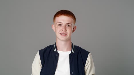 portrait of cheerful red head caucasian teenage man with toothy smile.