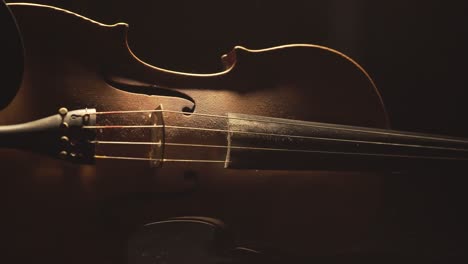 close up of old violin, dramatic light changes over the instrument , classical symphony music video footage