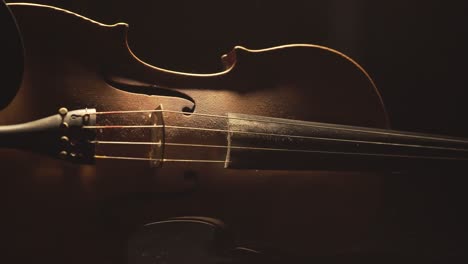primer plano de violín antiguo, cambios de luz dramáticos sobre el instrumento, secuencias de video de música sinfónica clásica