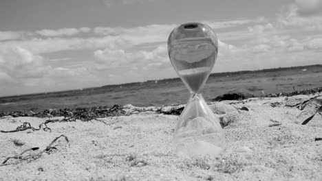 reloj de arena en la playa en blanco y negro.