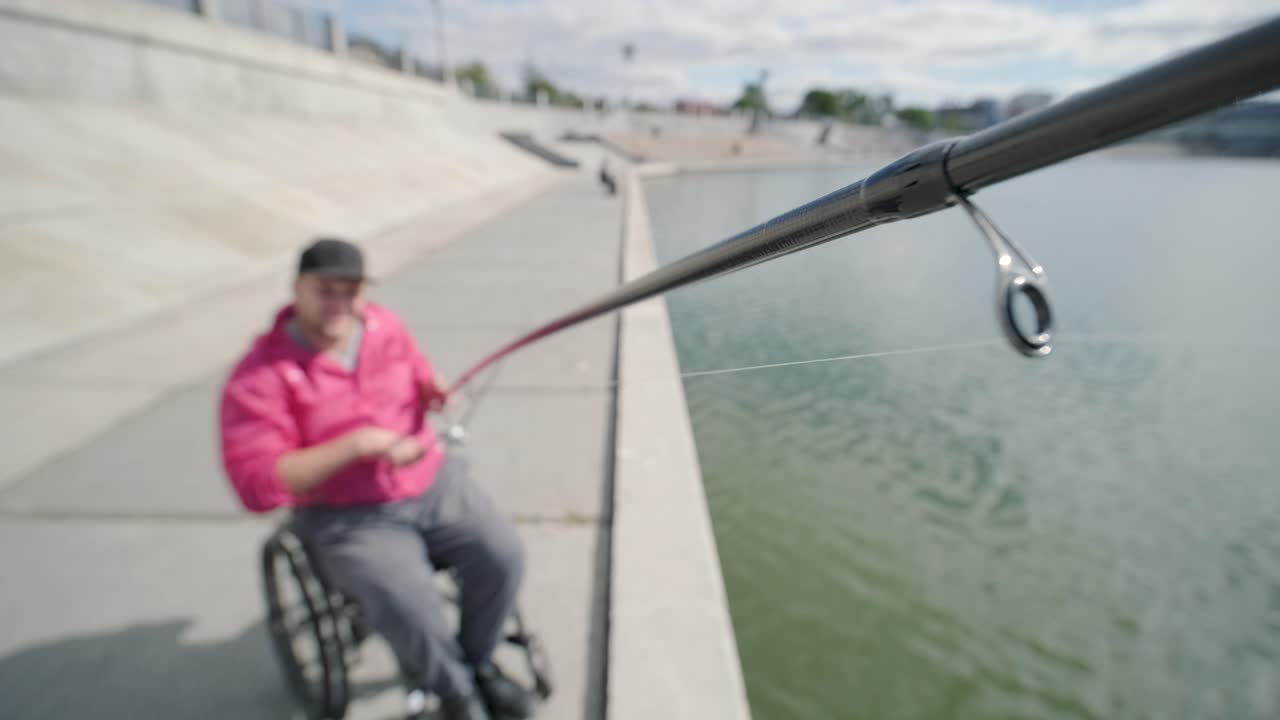 persona con discapacidad física que utiliza silla de ruedas para pescar en el muelle de pesca