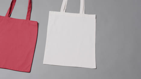 Close-up-of-red-and-white-bags-on-grey-background,-with-copy-space,-slow-motion