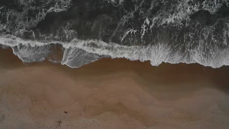 Aerial-view-of-a-beach-with-strong-waves-coming-in