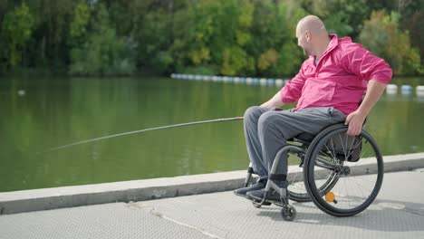 persona con discapacidad física que utiliza silla de ruedas para pescar en el muelle de pesca