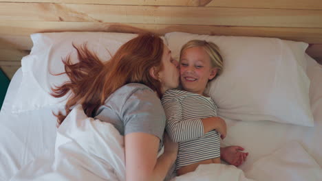 bed, wake up and a mother kissing her daughter