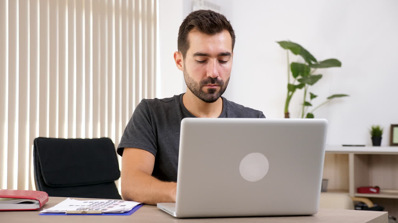 hombre trabajando en una computadora portátil en el escritorio