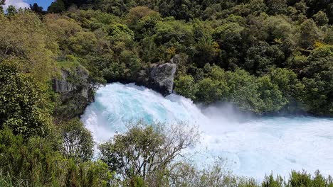 vista lateral en cámara lenta de las increíbles cataratas de hula que fluyen rodeadas por el hermoso bosque nativo de nueva zelanda