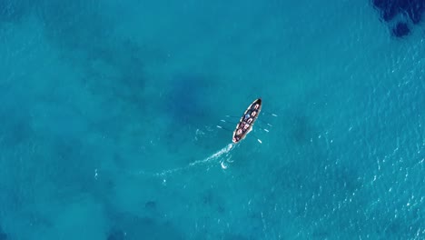 birds eye view drone shot of a team of rowers on a rowing boat on water