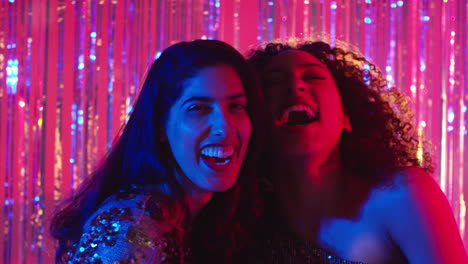 Portrait-Of-Two-Women-Friends-Having-Fun-Dancing-In-Nightclub-Bar-Or-Disco-With-Sparkling-Lights-2