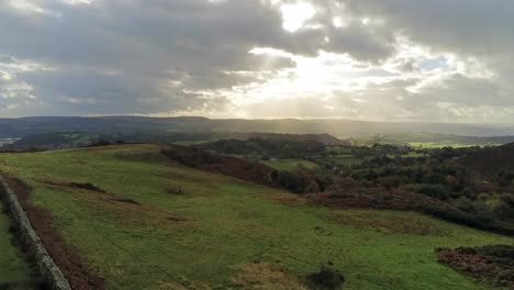 Rayos-De-Sol-Moviéndose-A-Través-De-Mosaico-Rural-Campo-Pradera-Paisaje-De-Tierras-De-Cultivo-Vista-Aérea-Ascendente