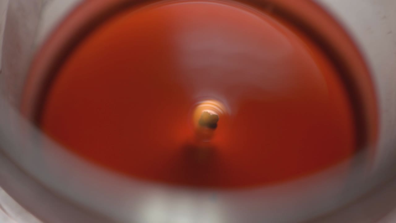 Red Wax Candle With Small Flame In A Glass - top shot