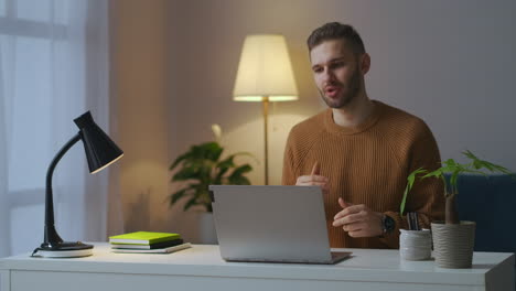 man is communicating with colleagues or partners by video chat in laptop online communication and negotiation male portrait in room