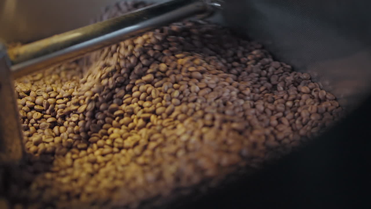 Close up of Roasting Coffee Beans in Metal Drum Baskets with Large Metal Furnaces, Mixing with Turning Blades in slowmo