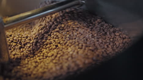 Close-up-of-Roasting-Coffee-Beans-in-Metal-Drum-Baskets-with-Large-Metal-Furnaces,-Mixing-with-Turning-Blades-in-slowmo