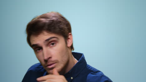 bearded man dancing on blue background. handsome guy looking at camera in studio