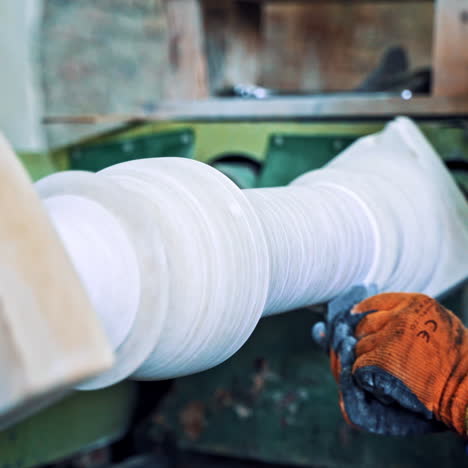 worker man in special uniform with mask polishing stone in workshop. laborer is working at the grinder machine on the old factory background. camera moves forward.