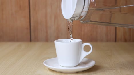 water being poured into a white cup