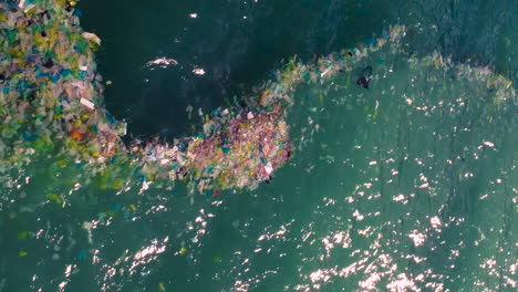 vertical shot of plastic bags and rubbish floating in sea waters