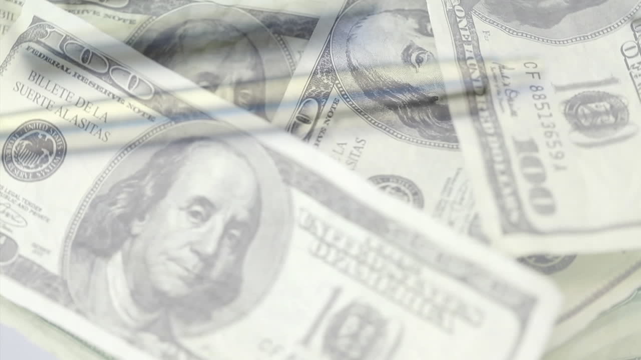 Animation af amerikanske dollar-sedler, lommeregner og en notesbog, der roterer.