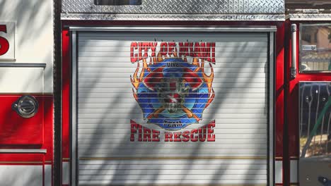 a large banner on a fire truck displays the official city of miami fire rescue insignia, a bold emblem of pride and dedication, standing out as the truck remains ready for service.