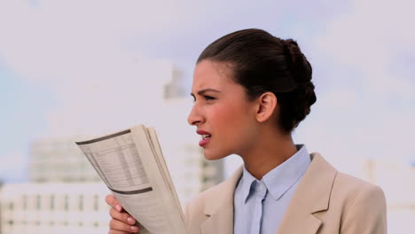 encantada hermosa mujer de negocios leyendo el periódico