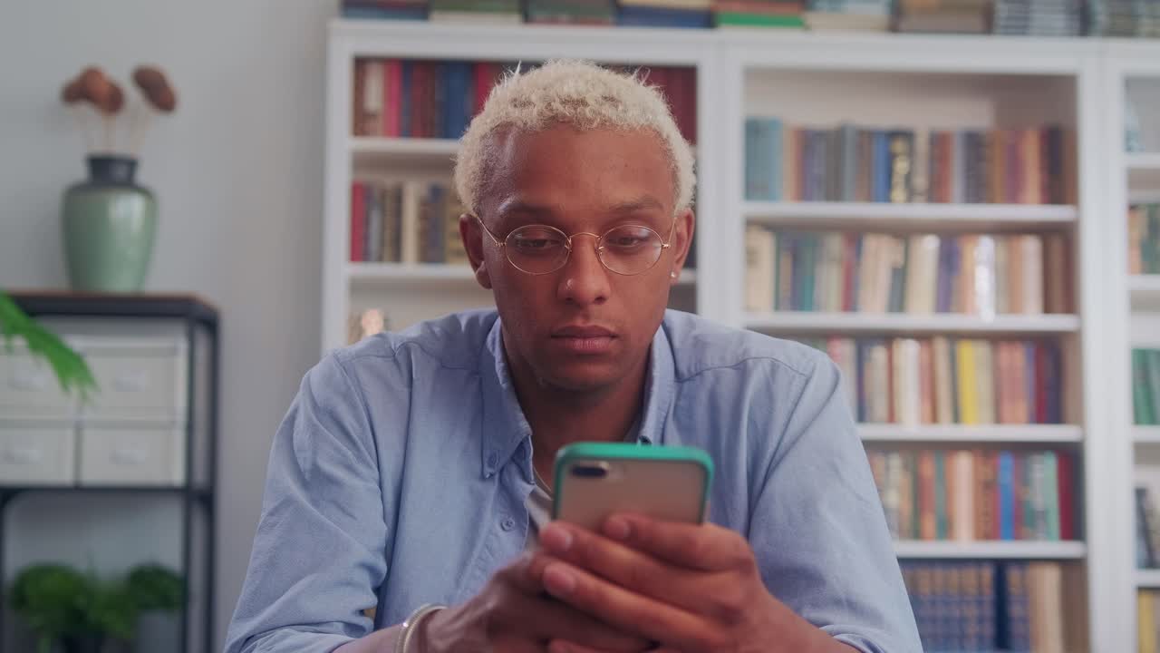 Close up of african man using smartphone chat with friends at desk home office