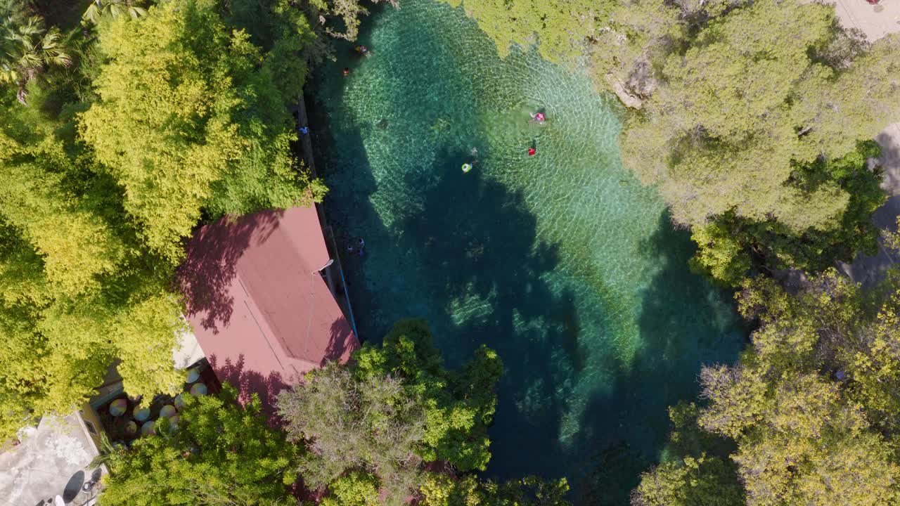 Persone che nuotano nell'acqua di sorgente cristallina del Monumento Naturale Las Marias a Neiba, Repubblica Dominicana - ripresa aerea