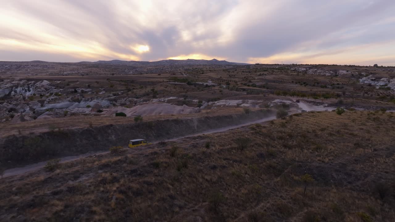 Flotta di SUV che attraversa una valle rocciosa sotto le sfumature del tramonto, Ortahisar